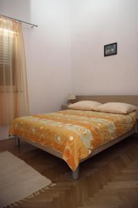 a bed with an orange blanket on it in a room at Villa Srima in Vodice