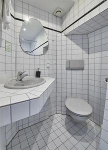 ein Badezimmer mit einem WC, einem Waschbecken und einem Spiegel in der Unterkunft Gästehaus Zur Traube in Reil
