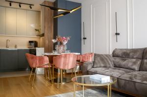 - un salon avec un canapé et une table avec des chaises dans l'établissement Supernova Royal Residence, à Novi Sad