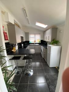 a kitchen with a table and a refrigerator at Leeward Lodge in Totland