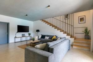 a living room with a couch and a staircase at Modern villa Amoroso with pool in Porec in Nova Vas