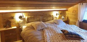1 dormitorio con 1 cama con pared de madera en Chalet le Grenier des Crosets, Vue exceptionnelle sur les Dents du Midi en Champéry