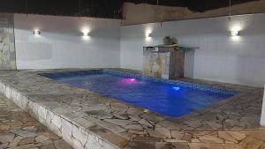 a swimming pool in a room with a stone floor at Casa Sol & Mar in Itanhaém