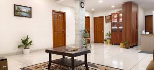 een lobby met een tafel in het midden van een kamer bij Sugamya Corner Guesthouse in Mysore