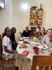 a group of people sitting at a dinner table at Lovely Pearl Intercity Homes in Dar es Salaam
