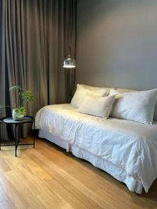 1 cama con sábanas blancas y almohadas en una habitación en Hermoso departamento en el corazón de la Recoleta en Buenos Aires