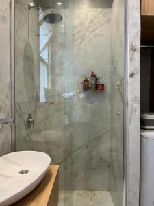 y baño con ducha acristalada y lavamanos. en Hermoso departamento en el corazón de la Recoleta en Buenos Aires