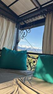 a bed with a view of the mountains through a window at La Villa in Kok-Shoky