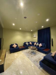a living room with a blue couch and a table at لوريت للشقق المخدومة in Jeddah