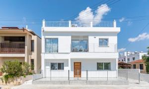 a white house with a fence in front of it at Kition City Apartments - Central Location in Larnaca +81 photos
