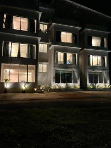 un gran edificio de apartamentos por la noche con luces en The Terra Hotel North Goa 