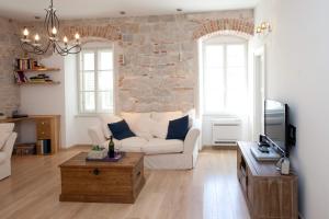 a living room with a white couch and a brick wall at Stylish Theatre Apartments in Split