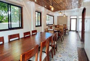 RedDoorz at Casa Rafaelle Transient Ilocos Sur في San Vincente: غرفة طعام مع طاولة وكراسي خشبية كبيرة