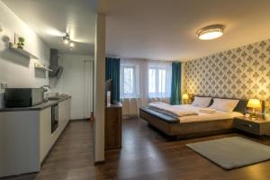 a bedroom with a bed and a kitchen with a sink at Apartment Queen Bridge in Sibiu