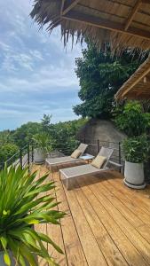 una terraza de madera con bancos y plantas en el techo en Villa Wao - Luxury, Privacy, Pool, Sea View in Koh Phangan, en Thong Sala