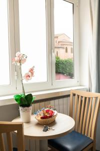 a table with a bowl of fruit in a window at Fleming Suites in Rome