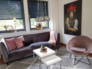 sala de estar con sofá y silla en Auszeit am Wildkatzenpfad en Bad Herrenalb