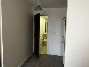 um corredor com uma porta que leva a uma casa de banho em At home Property em Manchester