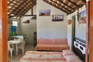 Habitación con 2 camas, mesa y comedor. en Chalés Ventos de Amarração, en Ponta do Anel