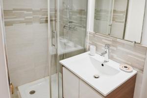 un bagno bianco con lavandino e doccia di 2 pièces de charme au coeur du village de CABRIS a Cabris Altre 10 foto