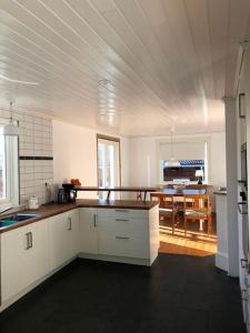 a kitchen with white cabinets and a table in it at Agunnaryd village holiday home - close to lake in Agunnaryd