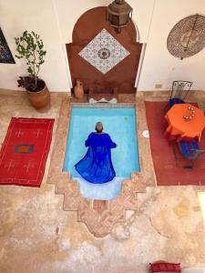 una mujer con un vestido azul de pie junto a una piscina en Riad Sophora - Peaceful Heaven in Marrakech, en Marrakech