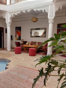 a living room with a table and red chairs at Riad Sophora - Peaceful Heaven in Marrakech in Marrakesh