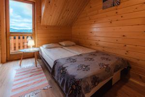 um quarto com uma cama num chalé de madeira em Witówka em Grywałd