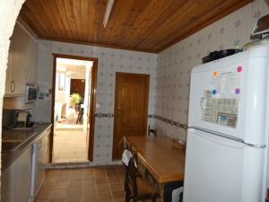 eine Küche mit einem weißen Kühlschrank und einer Holzdecke in der Unterkunft Casa de Pueblo - Costa Blanca in Oliva