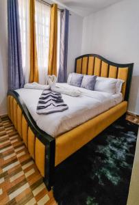 - un lit avec un cadre en bois et des serviettes dans l'établissement Spacious 1br Fully Furnished with Parking Nakuru, à Nakuru