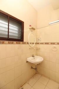 La salle de bains est pourvue d'un lavabo et d'un miroir. dans l'établissement Agarwal's Residency, à Visakhapatnam