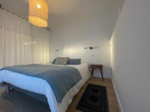 a bedroom with a bed with a blue blanket at Maison Particulière au Bono in Le Bono