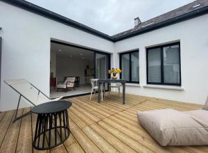a patio with a table and a couch at Maison Particulière au Bono in Le Bono