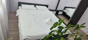1 dormitorio con 1 cama con sábanas blancas y espejo en Perfect View Apartament, en Bucarest