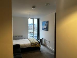 a bedroom with a bed and a large window at At home Property in Manchester