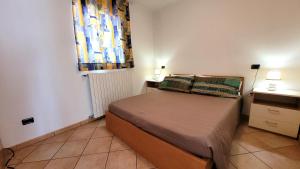 een kleine slaapkamer met een bed en 2 lampen bij La casa nel borgo Mountain Lake Iseo Hospitality in Bossico