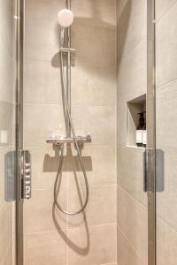 La salle de bains est pourvue d'une douche avec une porte en verre. dans l'établissement Maury - Luxury Loft - Heart of Montparnasse, à Paris
