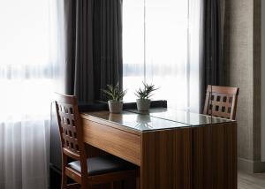 a desk with two plants on top of it next to a window at Lacoba Hotel in Athens