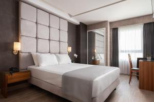 sypialnia z dużym białym łóżkiem i biurkiem w obiekcie Lacoba Hotel w Atenach