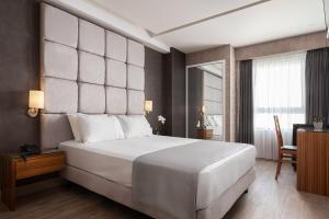 a bedroom with a large white bed and a desk at Lacoba Hotel in Athens