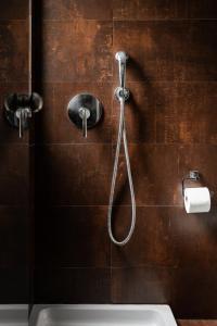 a shower with a hose attached to a wall at Lacoba Hotel in Athens