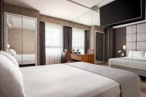 アテネにあるLacoba Hotelのベッド2台とデスクが備わるホテルルームです。