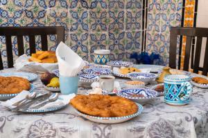 a table with blue and white plates of food on it at Dar Badiaa in Sousse
