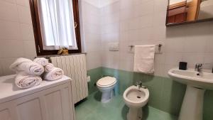 een witte badkamer met een toilet en een wastafel bij La casa nel borgo Mountain Lake Iseo Hospitality in Bossico