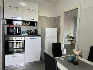 a kitchen with a table and a white refrigerator at MyCosmoStudio - Fiera in Pero