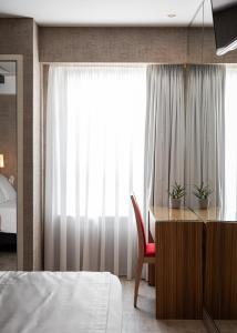 a bedroom with a desk and a bed and a window at Lacoba Hotel in Athens