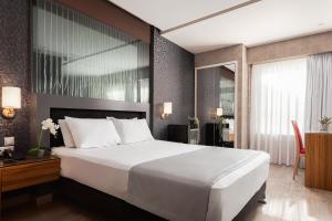 a bedroom with a large white bed and a desk at Lacoba Hotel in Athens
