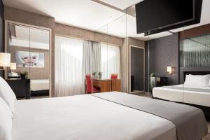 a hotel room with a large white bed and a desk at Lacoba Hotel in Athens