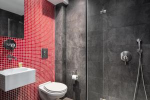 a bathroom with a toilet and a shower with red tile at Lacoba Hotel in Athens
