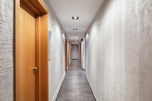 a corridor of corridors with wooden doors and concrete walls at Lacoba Hotel in Athens
